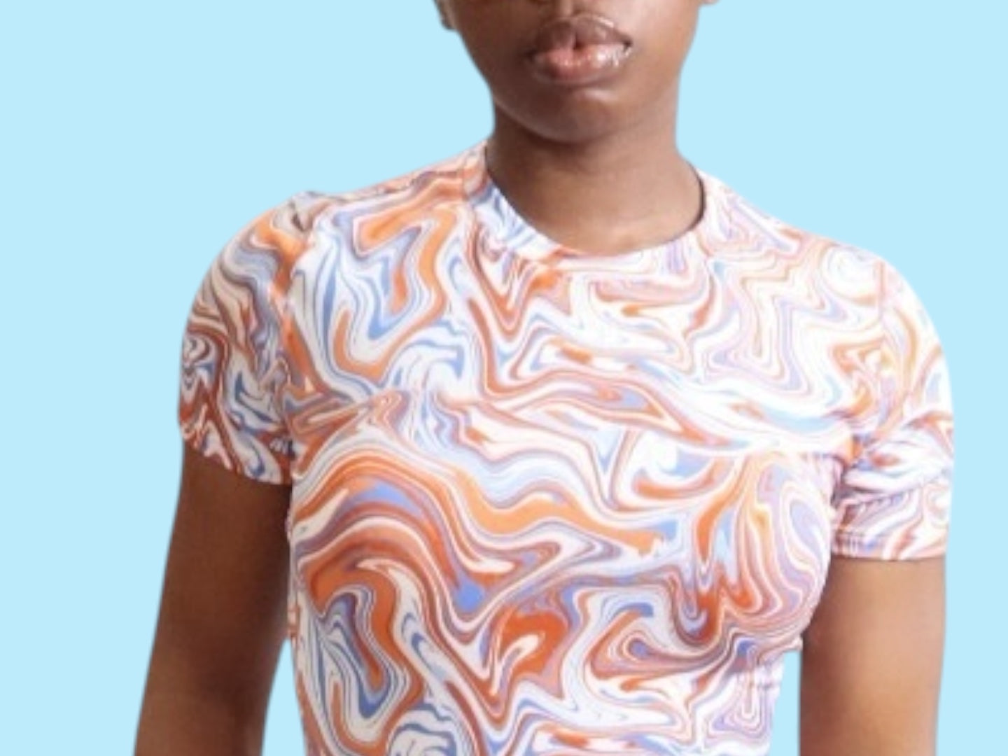 Woman wearing a blue, orange, and white with swirl pattern, close up view of pattern on a light blue background